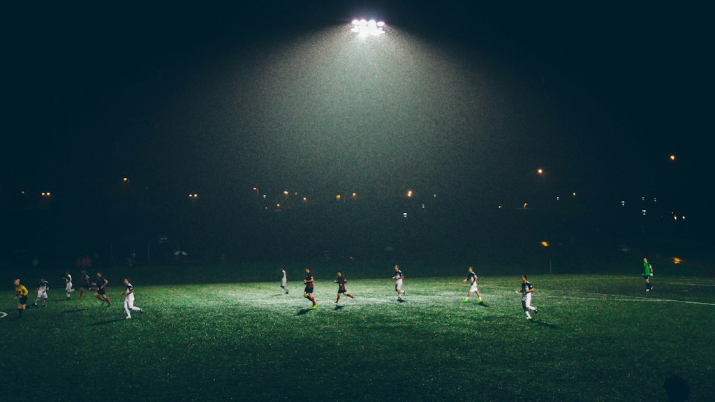 Football match underway under stadium lights
